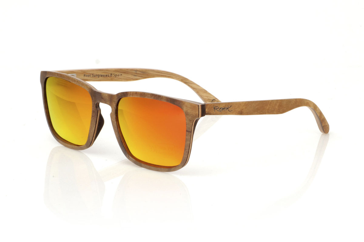 Wood eyewear of Burr OLIVER. OLIVER wooden sunglasses, medium in size and with a square shape with rounded and soft lines, are the perfect balance between design and nature. Made with a careful lamination of olive wood on the outside and interspersed with layers of beech wood, they stand out for the warm color and unique grain that olive wood offers. This combination not only provides exceptional resistance, but also makes each pair a unique piece. With a measurement of 145x47 and a caliber of 53, the OLIVER adapts wonderfully, offering comfort and unmistakable style to those who wear them. Ideal for those looking to stand out with an accessory that speaks of elegance and commitment to the environment. for Wholesale & Retail | Root Sunglasses® 